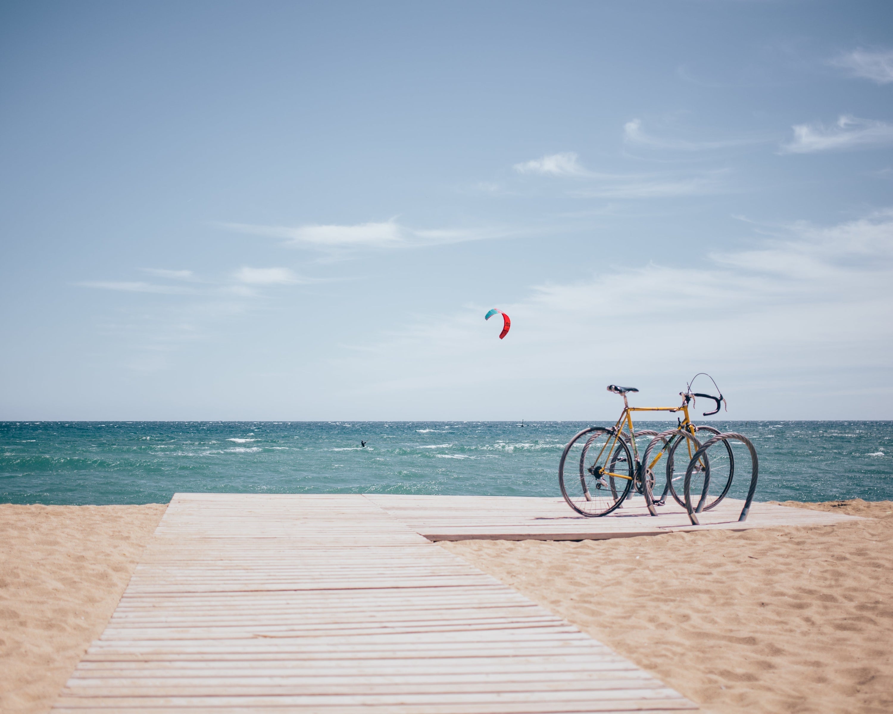 Bicycle on a wooden platform at the beach with ocean and sky in the background